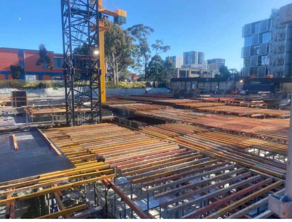 Apex podium deck formwork with joists and bearers under a tower crane